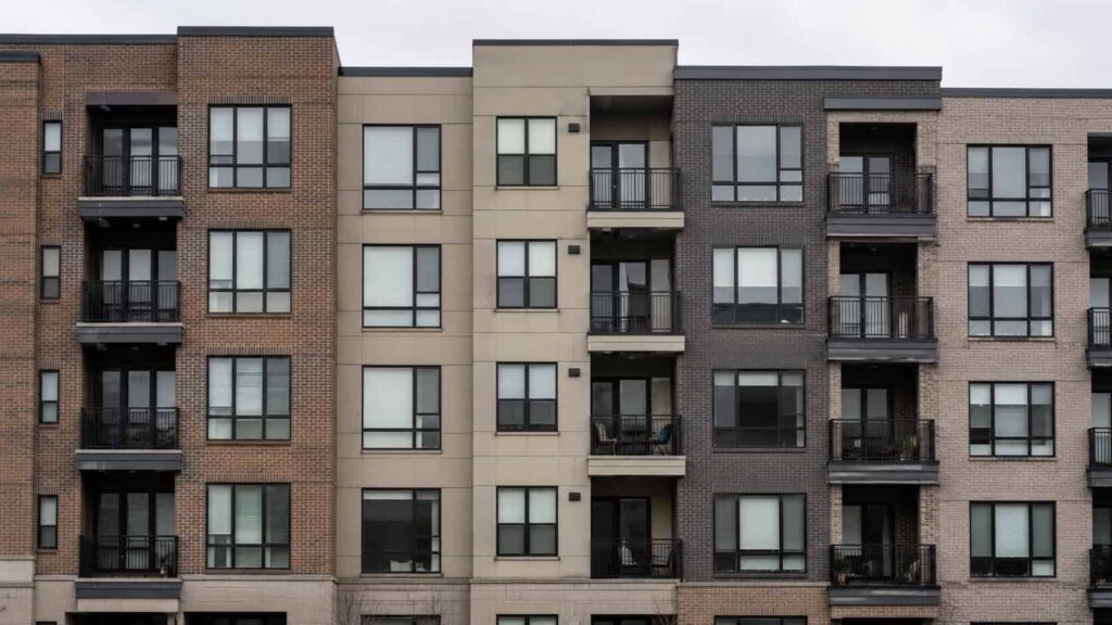 Mid-rise apartment building facade with repeating window openings and balconies