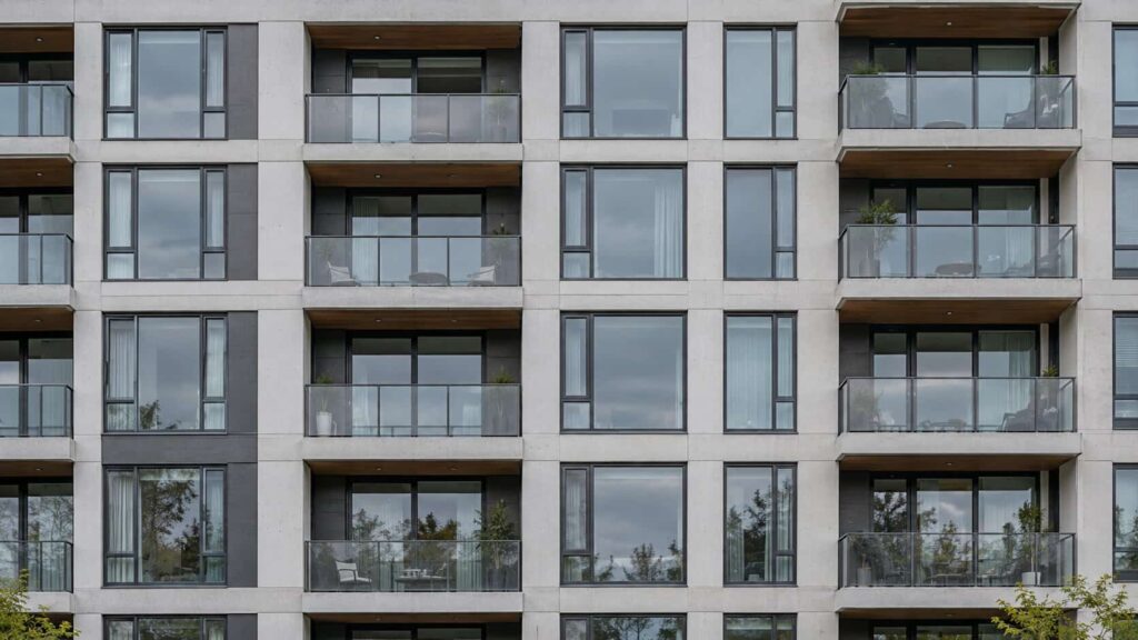 Apartment building facade with repeating windows and sliding balcony doors